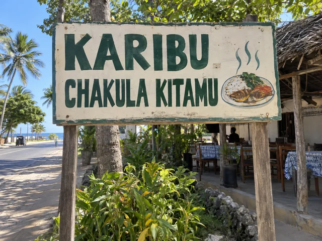 Illustrative roadside billboard reading “Karibu — Chakula kitamu”